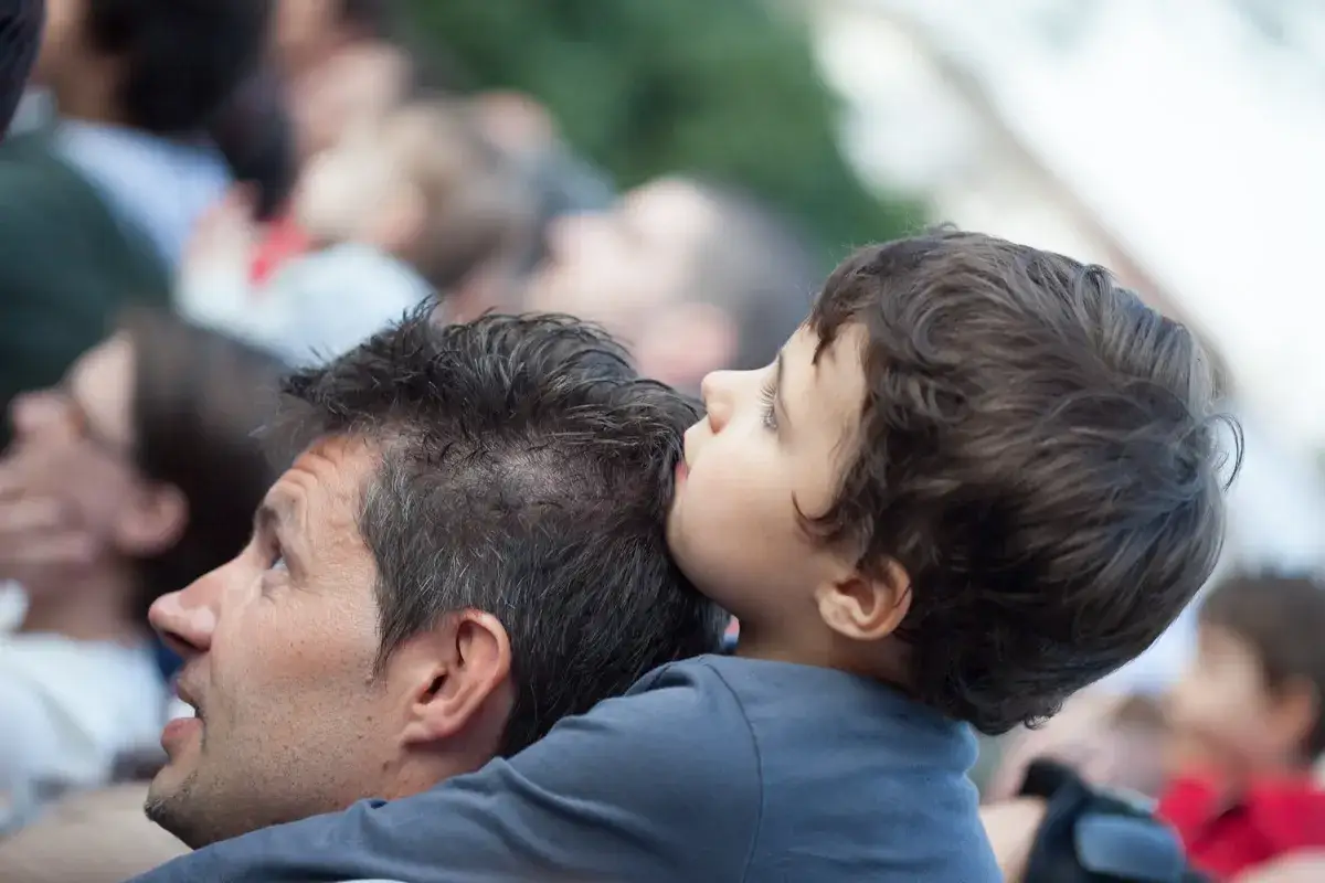 Bambino appoggiato alla testa di un uomo, con un'espressione di profondo attaccamento disorganizzato.