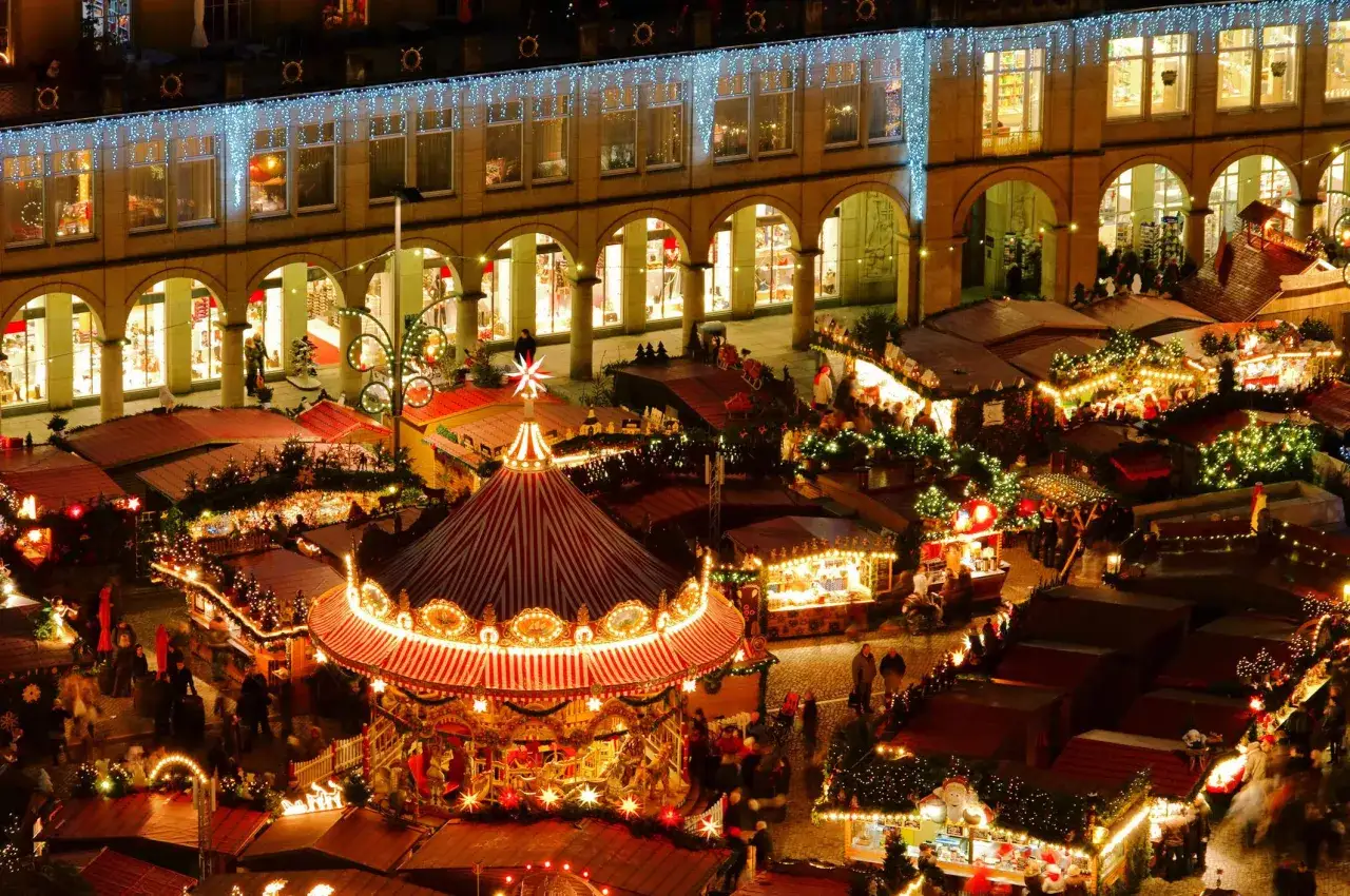 Mercado navideño con tiovivo y puestos iluminados. Un lugar ideal donde ir en Navidad en España con niños para disfrutar de la magia.
