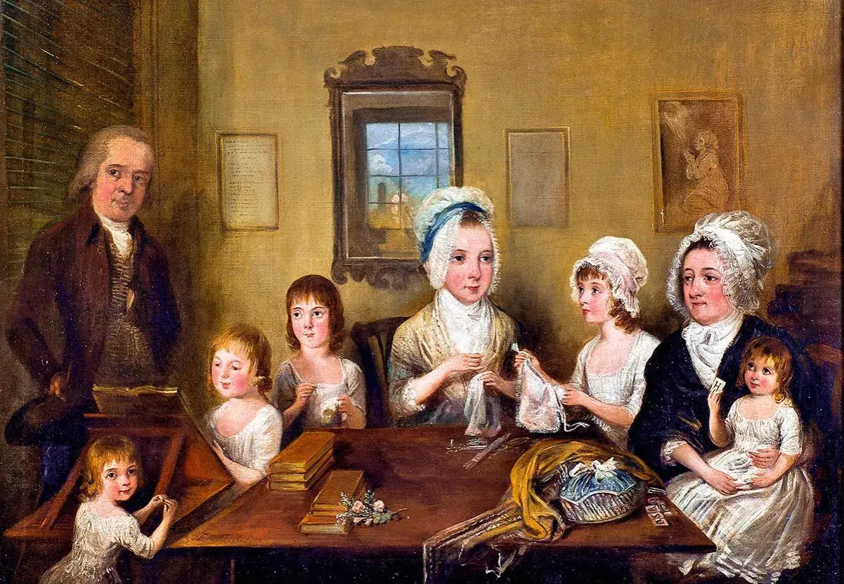 En familj samlad runt ett bord, kanske som Carl Michael Bellman barn, med en man som läser och barn som sysslar med handarbete.