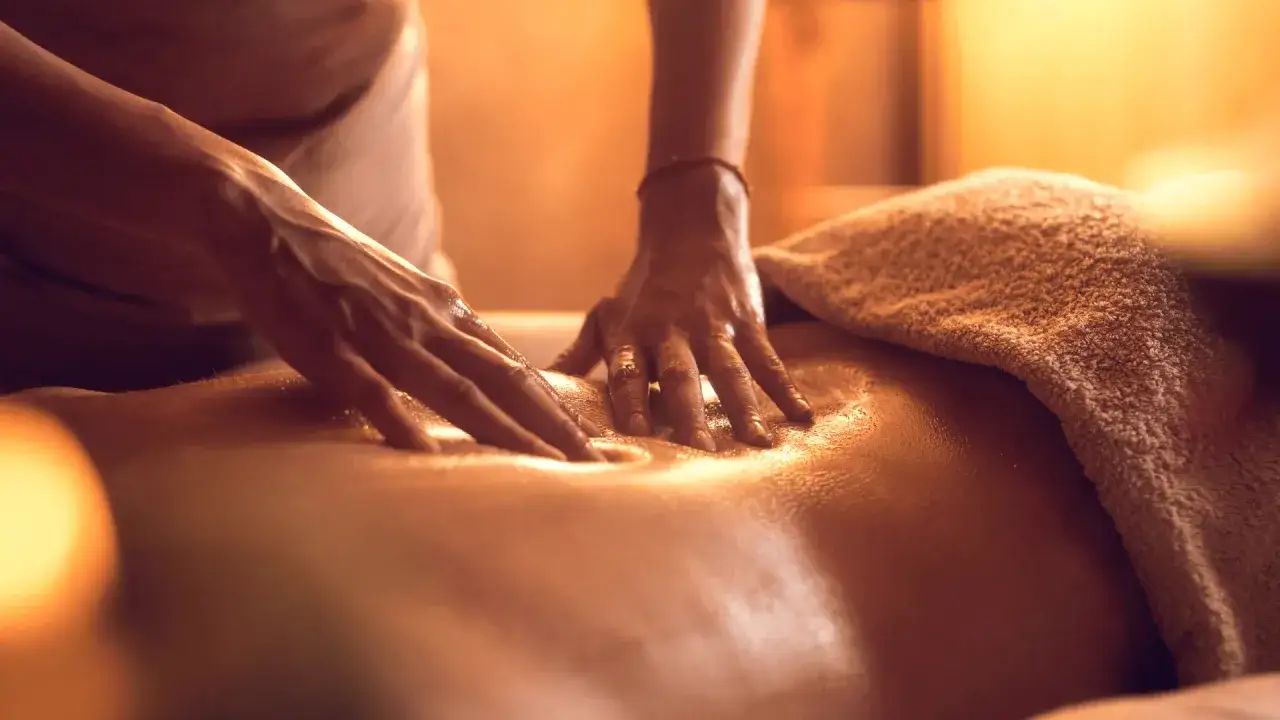 Dłonie terapeuty wykonują masaż pleców. To właśnie masaż shiatsu co to jest, japońska sztuka uzdrawiania przez dotyk.