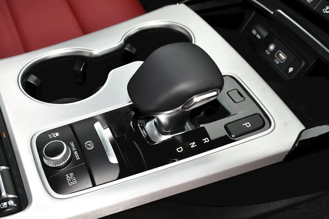 Palanca de cambios y consola central de un Kia Stinger CV, con selector de modo de conducci&oacute;n y freno de mano electr&oacute;nico.