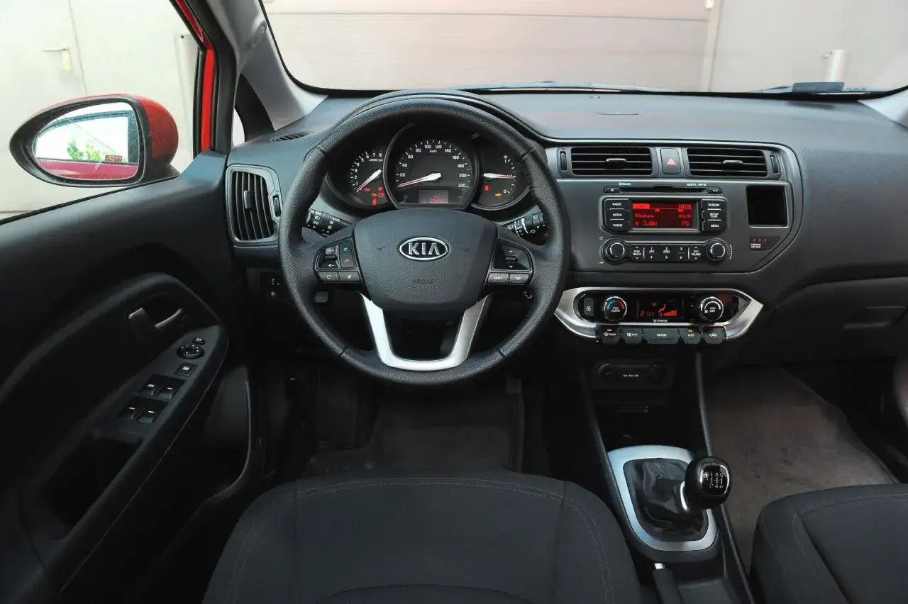 Wnętrze Kia Rio 3: kierownica, deska rozdzielcza z radiem i nawiewami, dźwignia zmiany biegów.
