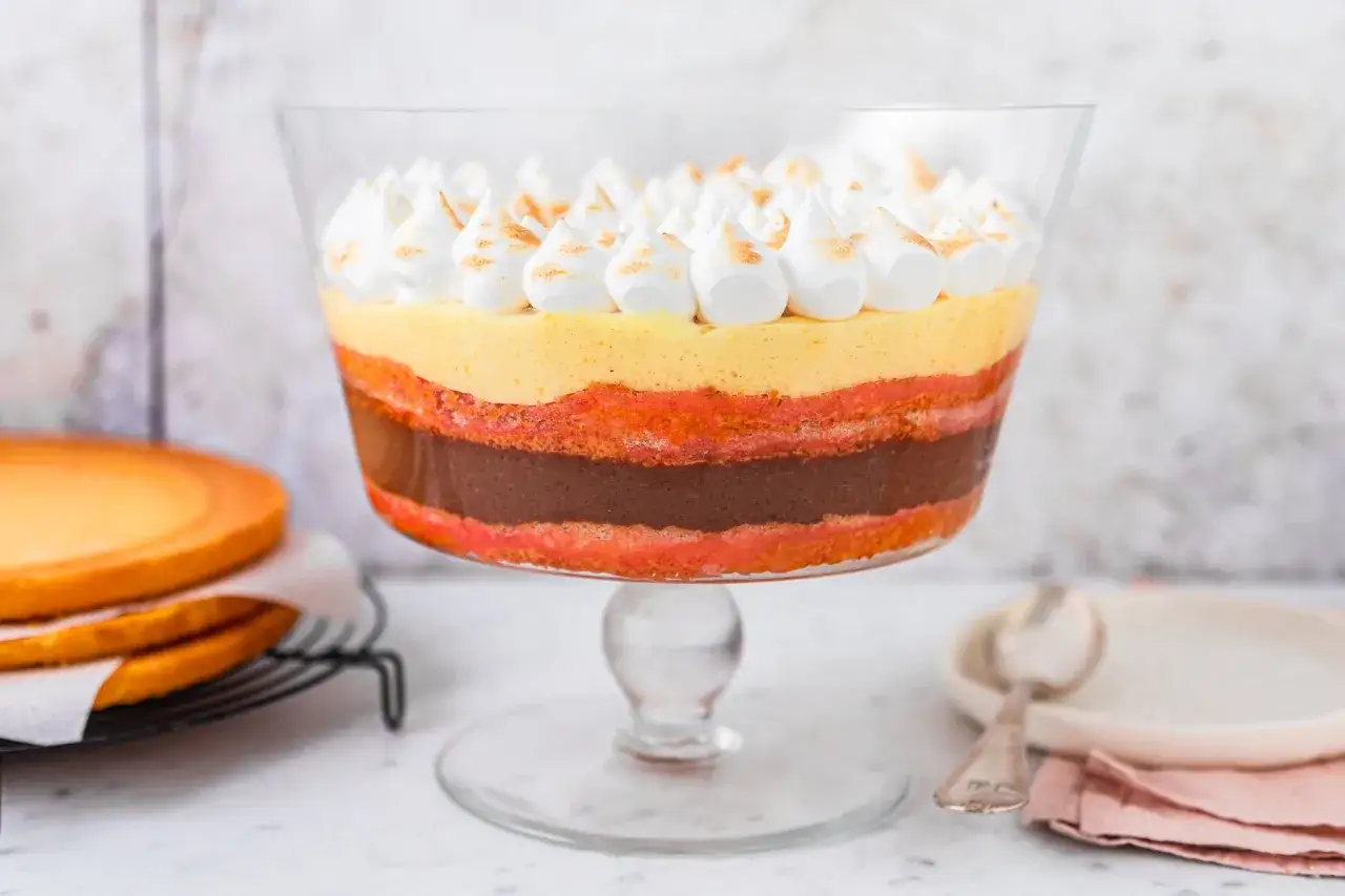 Deliziosa zuppa inglese ricetta in coppa, con strati di pan di Spagna, crema pasticcera, cioccolato e meringhe.