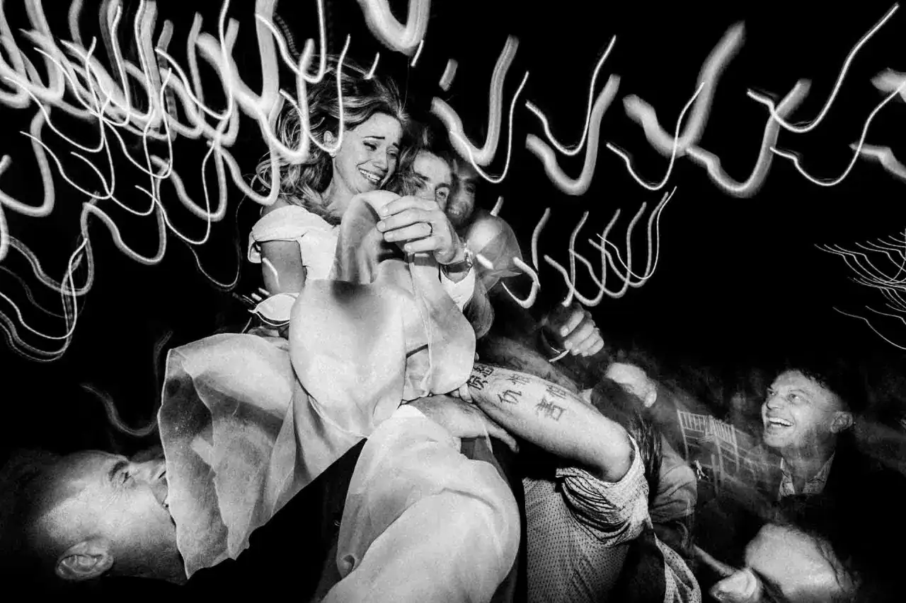 foto invitati matrimonio: sposi felici tra luci e volti gioiosi, un momento di festa indimenticabile.