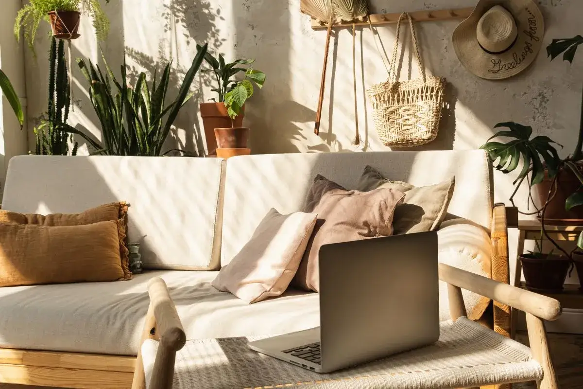 Sofa z poduszkami, mn&oacute;stwo roślin i pleciona torba na ścianie &ndash; tak czym charakteryzuje się styl boho.