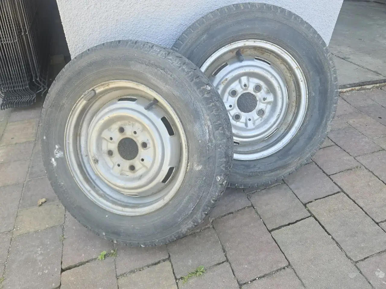 Dwa koła do Fiata 126p, które kiedyś nadawały mu elegancki wygląd, teraz leżą na chodniku.