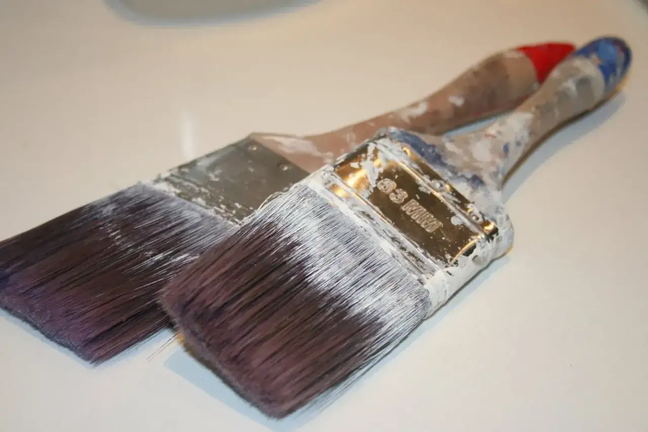 Deux pinceaux usag&eacute;s, couverts de peinture blanche s&eacute;ch&eacute;e. Que faire avec ce pinceau sec ?