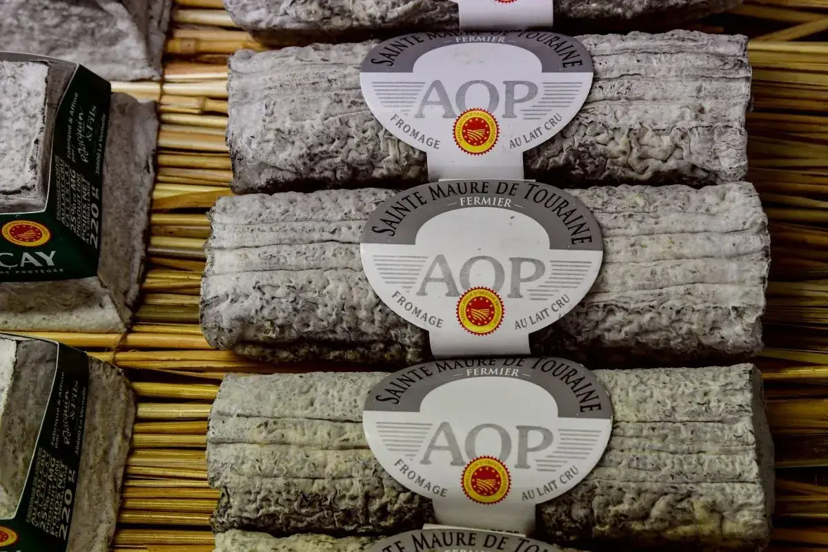 B&acirc;tonnets de fromage de ch&egrave;vre AOP Sainte-Maure de Touraine, au lait cru, pr&eacute;sent&eacute;s sur des nattes. L'AOP garantit leur origine et qualit&eacute;.