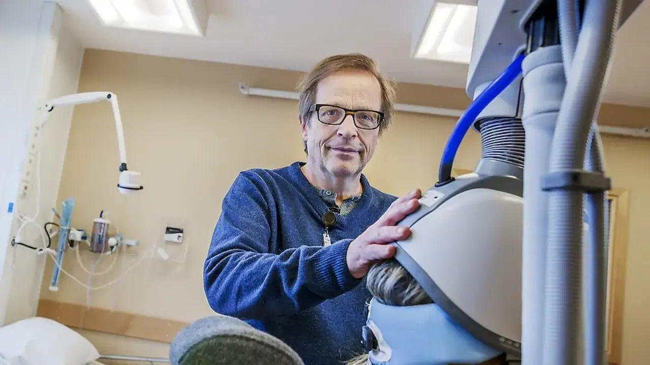 Läkare förbereder elchock behandling. Patienten har en apparat på huvudet.