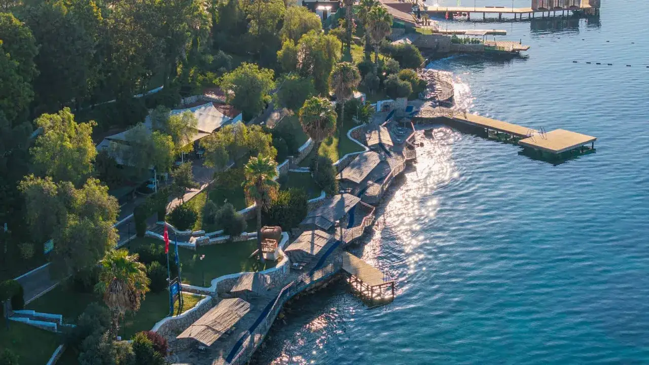 Malowniczy brzeg z pomostami i zacienionymi miejscami do wypoczynku, idealny na relaks w **Duja Bodrum**.