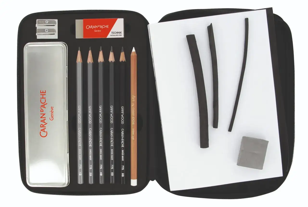 Une trousse d'artiste amateur avec crayons, fusains, gomme et taille-crayon.