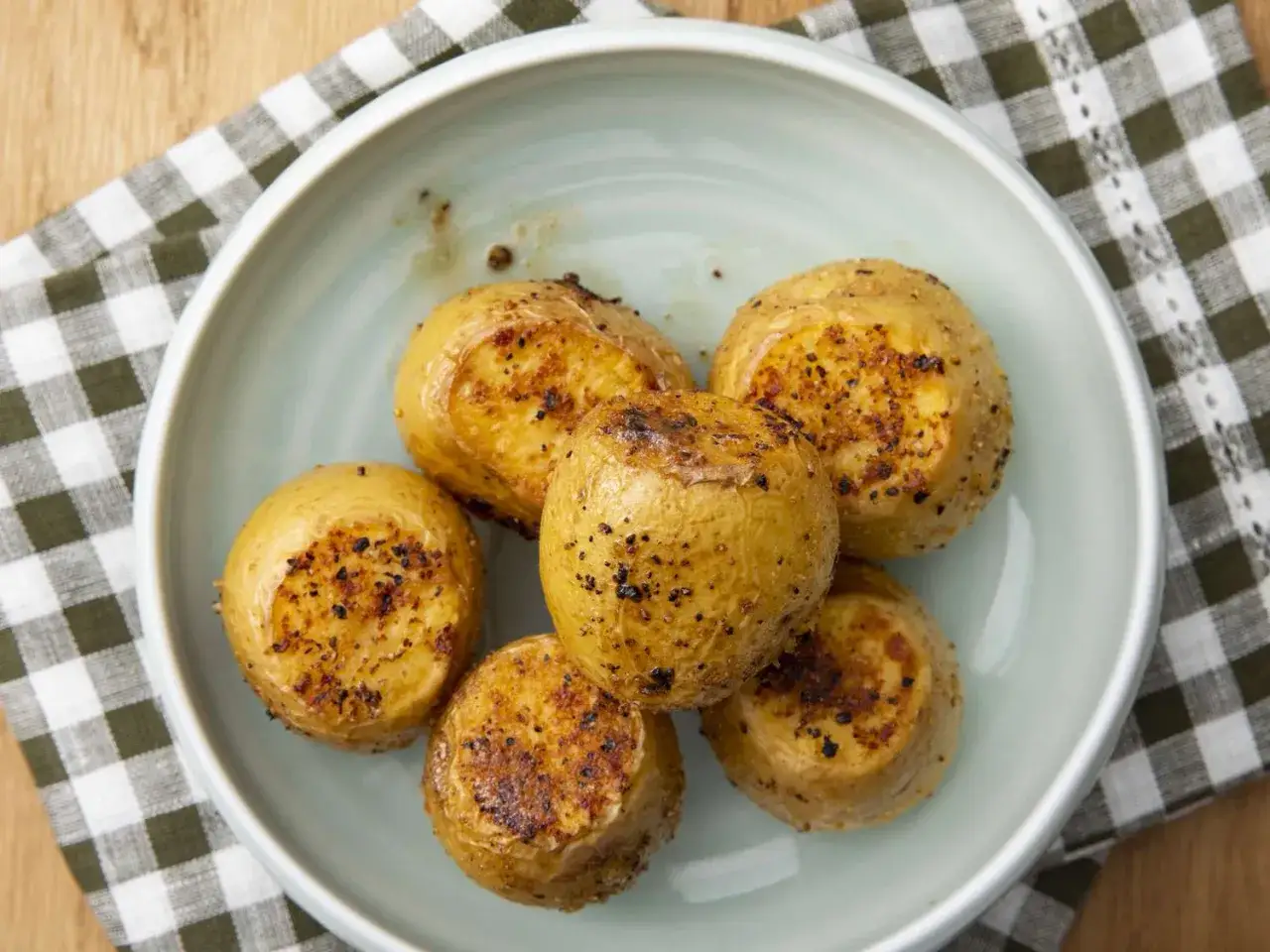 Patatas asadas en freidora de aire, doradas y crujientes, listas para disfrutar. El tiempo perfecto para un aperitivo delicioso.