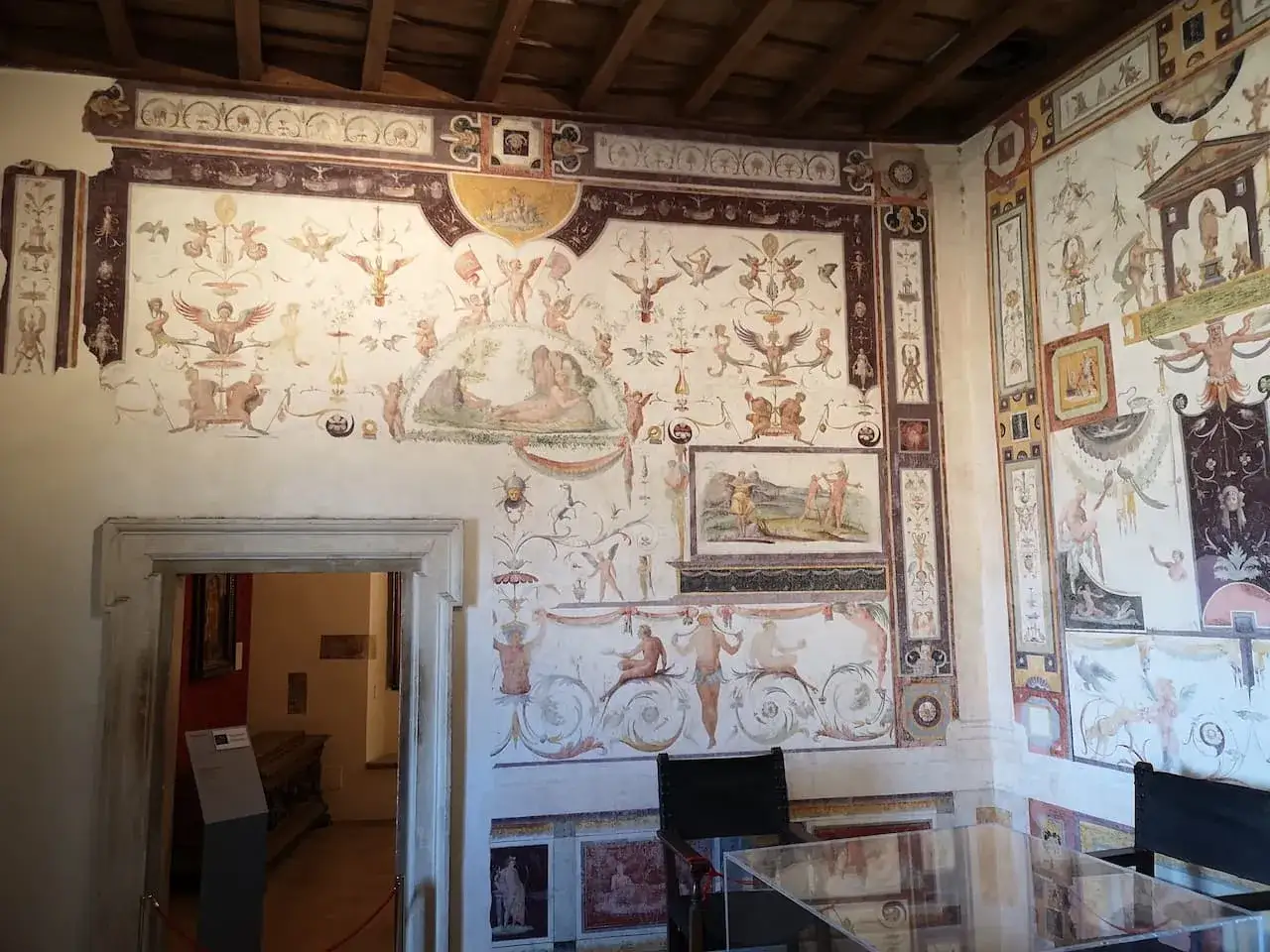 Intérieur du **château Saint-Ange** : fresques mythologiques ornant les murs d'une pièce, avec une porte ouverte sur une autre salle.