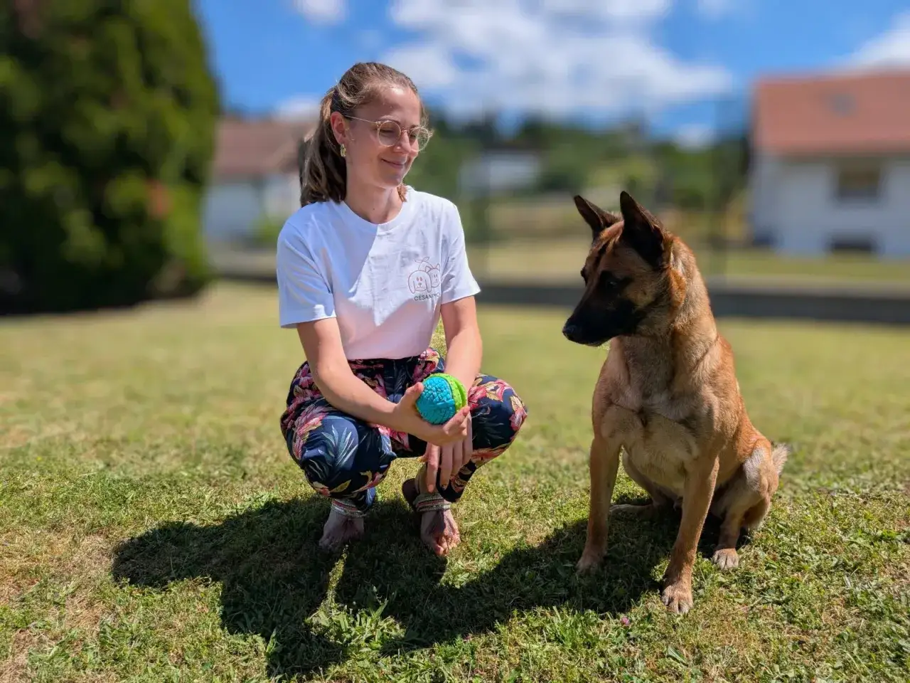 Une jeune femme avec une balle pour chien, un bon exemple de comment faire garder son chien en toute confiance.