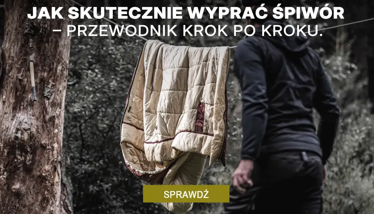 Jak prać śpiwór? Przewodnik krok po kroku. Śpiwór schnie na drzewie, obok stoi osoba w czarnej bluzie.