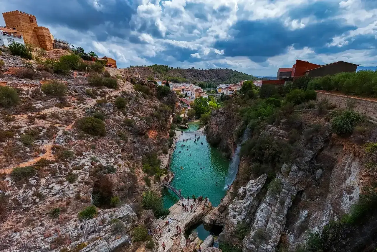 Un pueblo con un castillo en lo alto, rodeado de monta&ntilde;as, y un r&iacute;o de aguas turquesas donde la gente se ba&ntilde;a. &iexcl;Bolbaite fotos de ensue&ntilde;o!