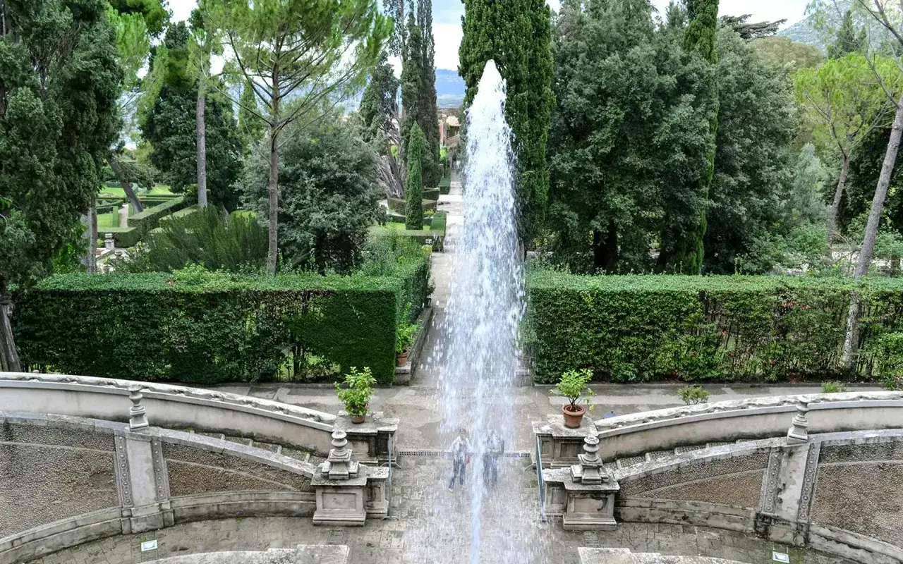 Wspaniała fontanna w ogrodach Villa d'Este, otoczona zielenią i geometrycznymi żywopłotami, tworzy magiczną atmosferę.