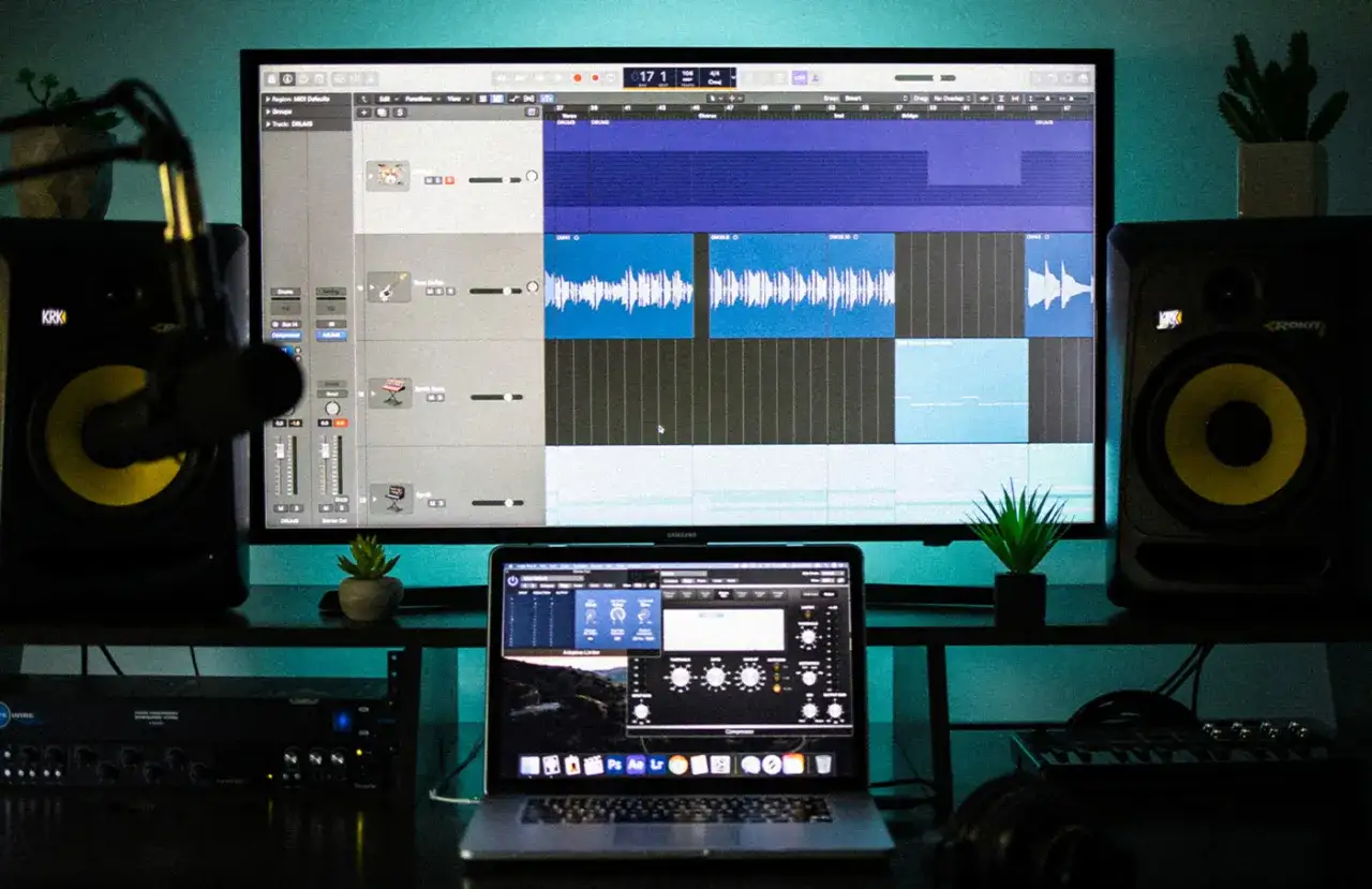 Studio d'enregistrement avec écran affichant un DAW, des enceintes et un ordinateur portable. Idéal pour créer de la musique avec des **free daw windows**.