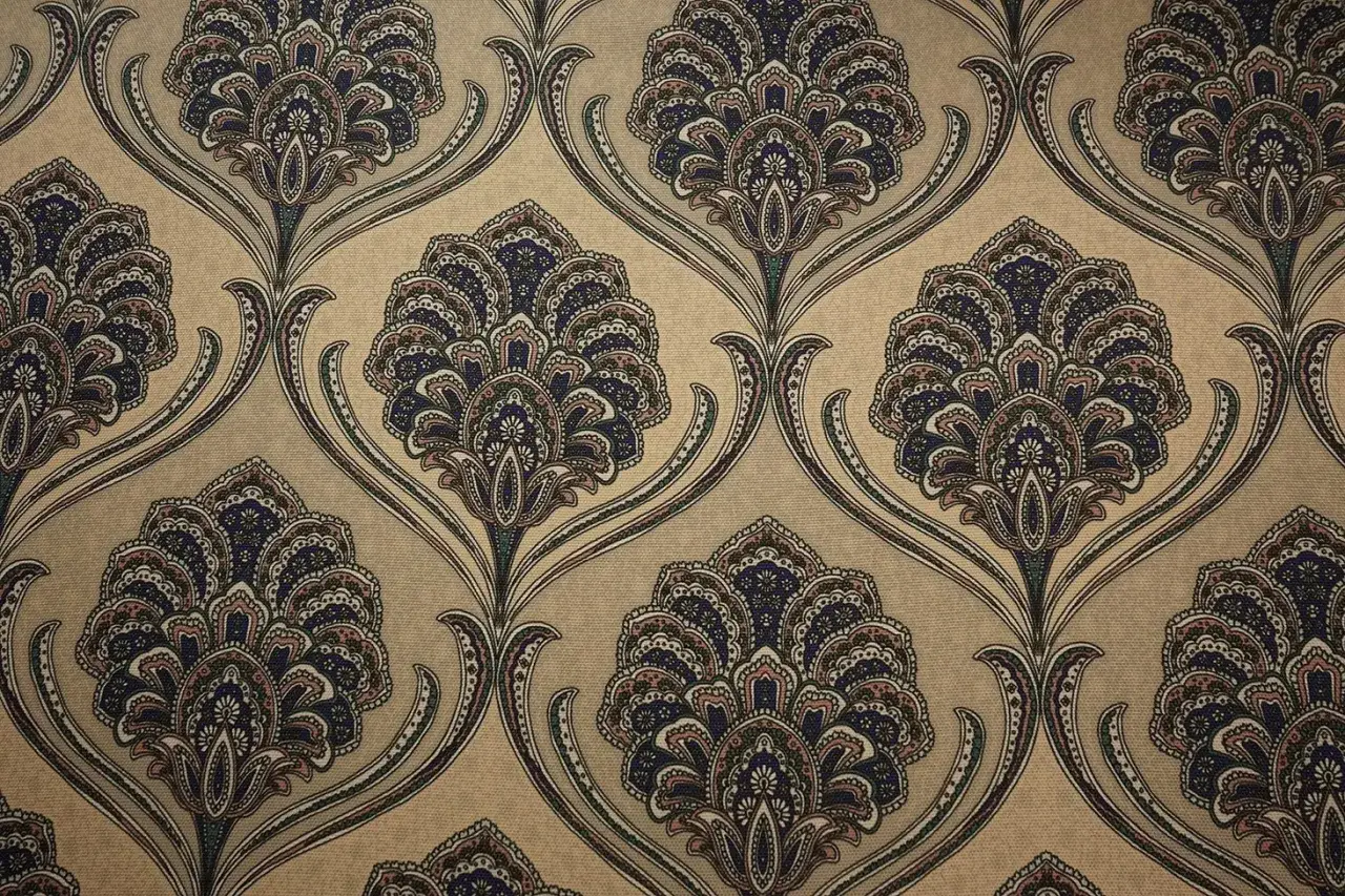 Wzór żakardowy w stylu paisley na beżowym tle. Granatowe, brązowe i różowe kwiaty tworzą elegancką, powtarzalną kompozycję.