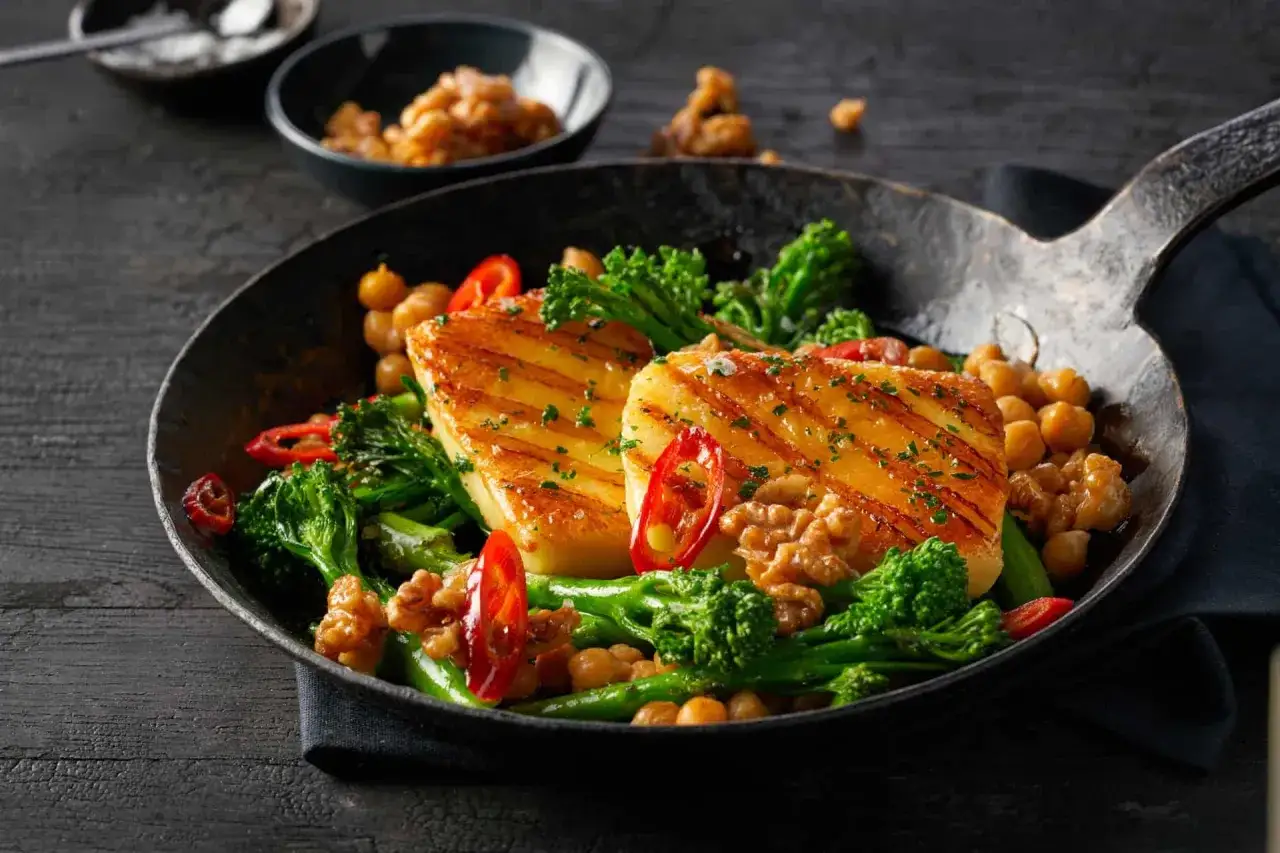 Gebratener Brokkoli mit Kichererbsen, Walnüssen und gegrilltem Halloumi in einer Pfanne.