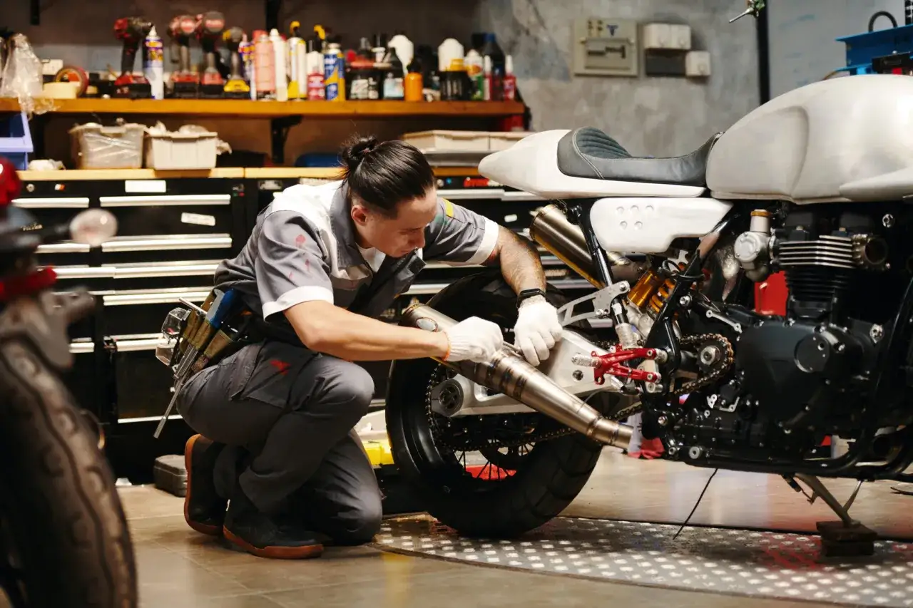 Mec&aacute;nico trabajando en el escape de una moto custom, prepar&aacute;ndola para su homologaci&oacute;n.