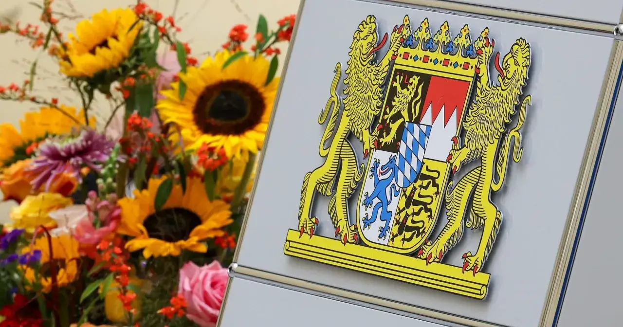 Wappen von Bayern und Franken, daneben ein bunter Blumenstrauß mit Sonnenblumen.