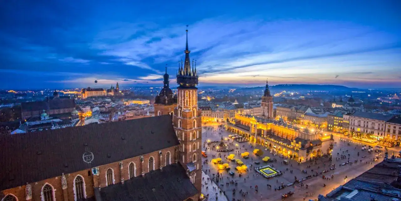 Krakow's Main Market Square at dusk, a highlight of my Poland trip. The historic Cloth Hall glows, with St. Mary's Basilica towering over the scene.