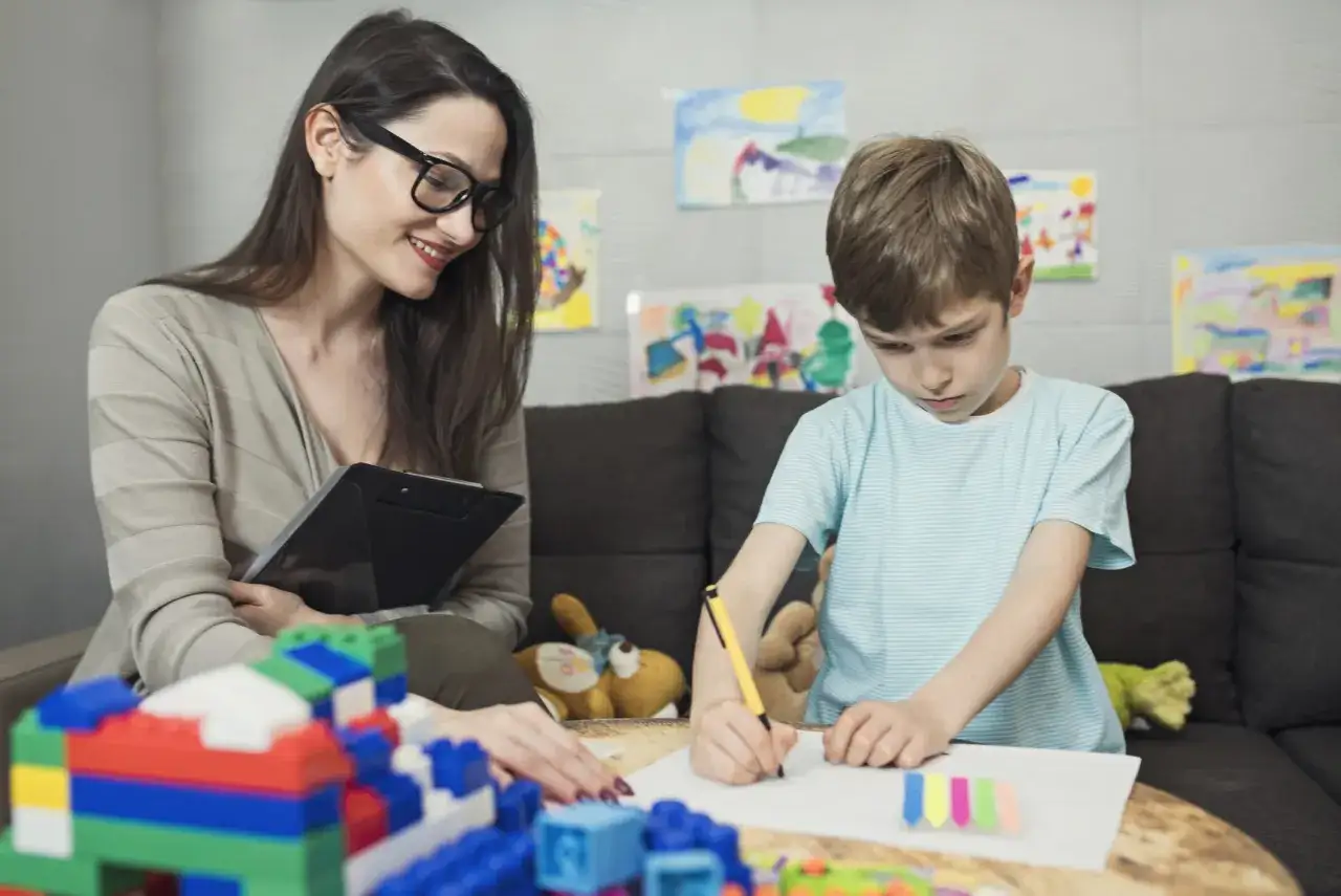 nauczyciel terapeuta pracujący z dzieckiem w gabinecie pedagogicznym