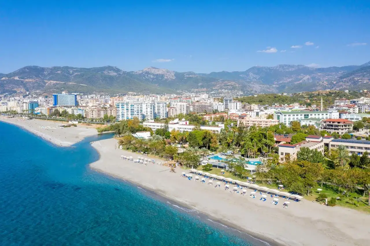 Widok na wybrzeże z hotelami i górami w tle. Idealne miejsce na wyjazd do Turcji, z piaszczystą plażą i turkusowym morzem.