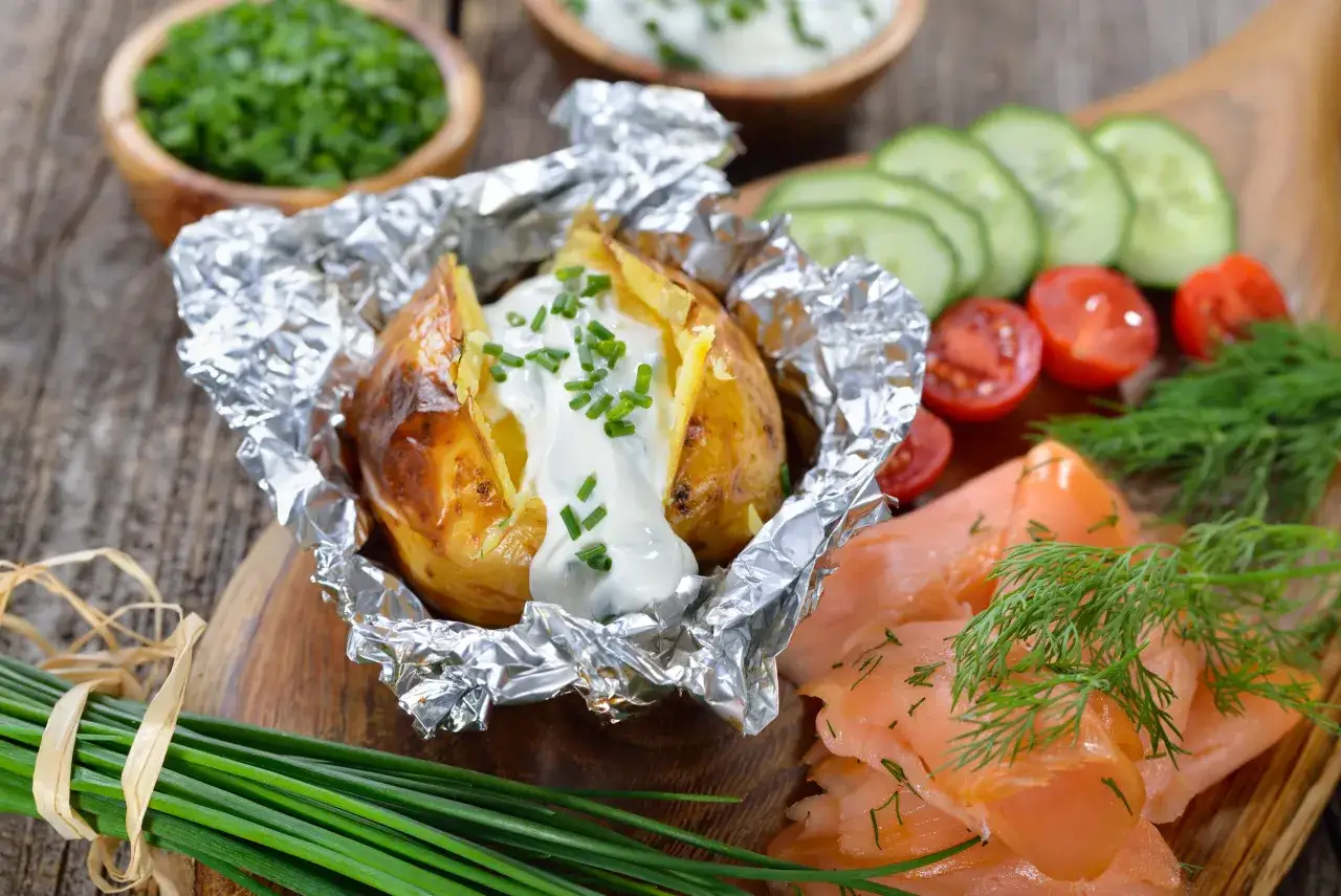 Gebackene Kartoffeln mit Quark und Schnittlauch, dazu Lachs, Tomaten und Gurken. Ein köstliches Gericht!
