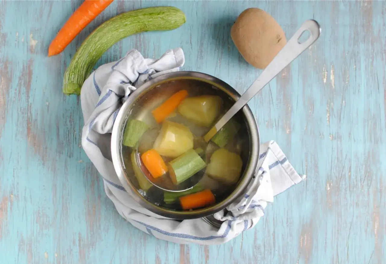 Brodo vegetale neonati: carote, zucchine e patate bollite in pentola, pronte per essere frullate.