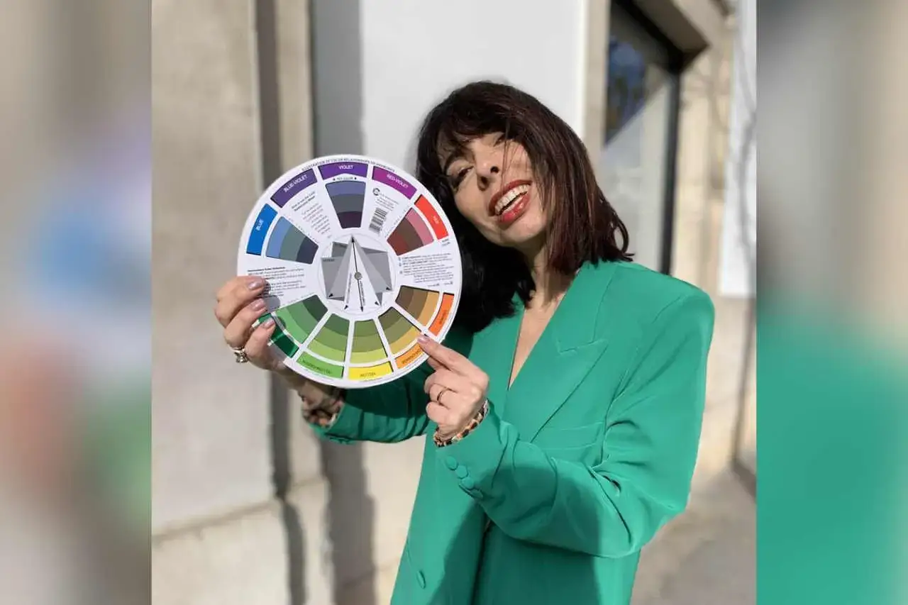 Donna con giacca verde brillante mostra una ruota dei colori, con una sezione dedicata al colore blu.