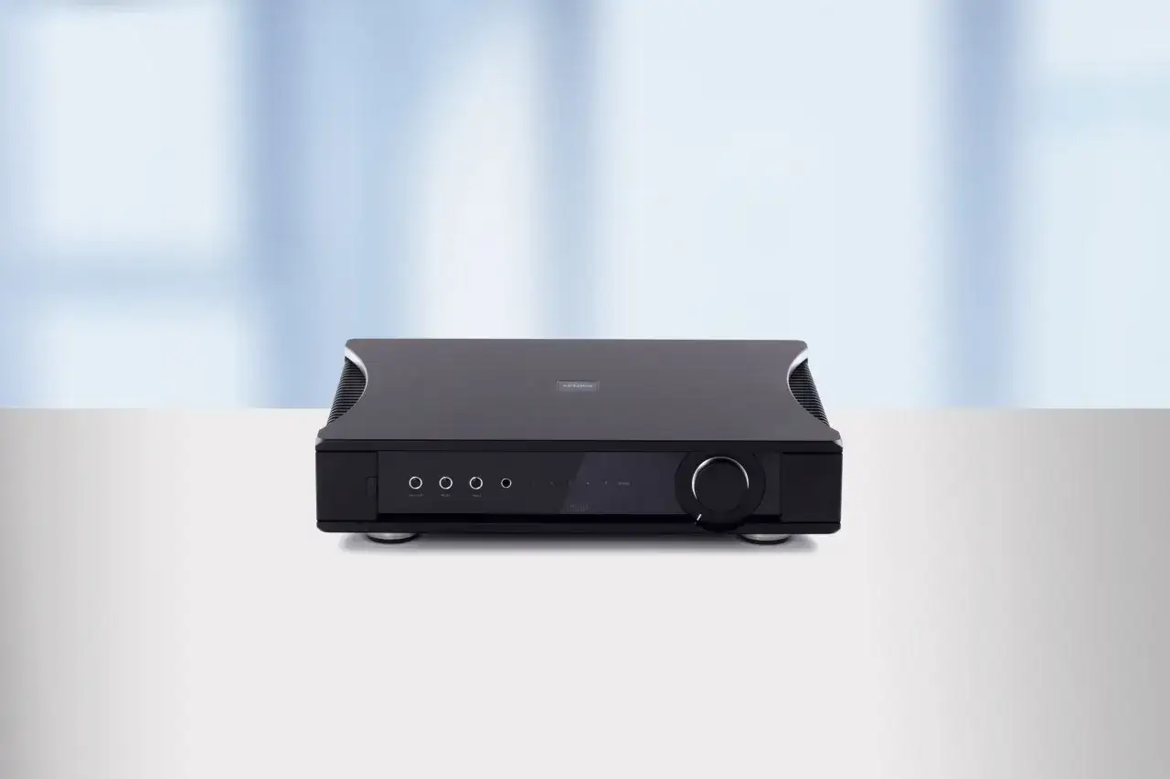 Le Rega Aethos, un amplificateur noir &eacute;l&eacute;gant, tr&ocirc;ne sur une surface blanche, pr&ecirc;t &agrave; diffuser un son de haute fid&eacute;lit&eacute;.