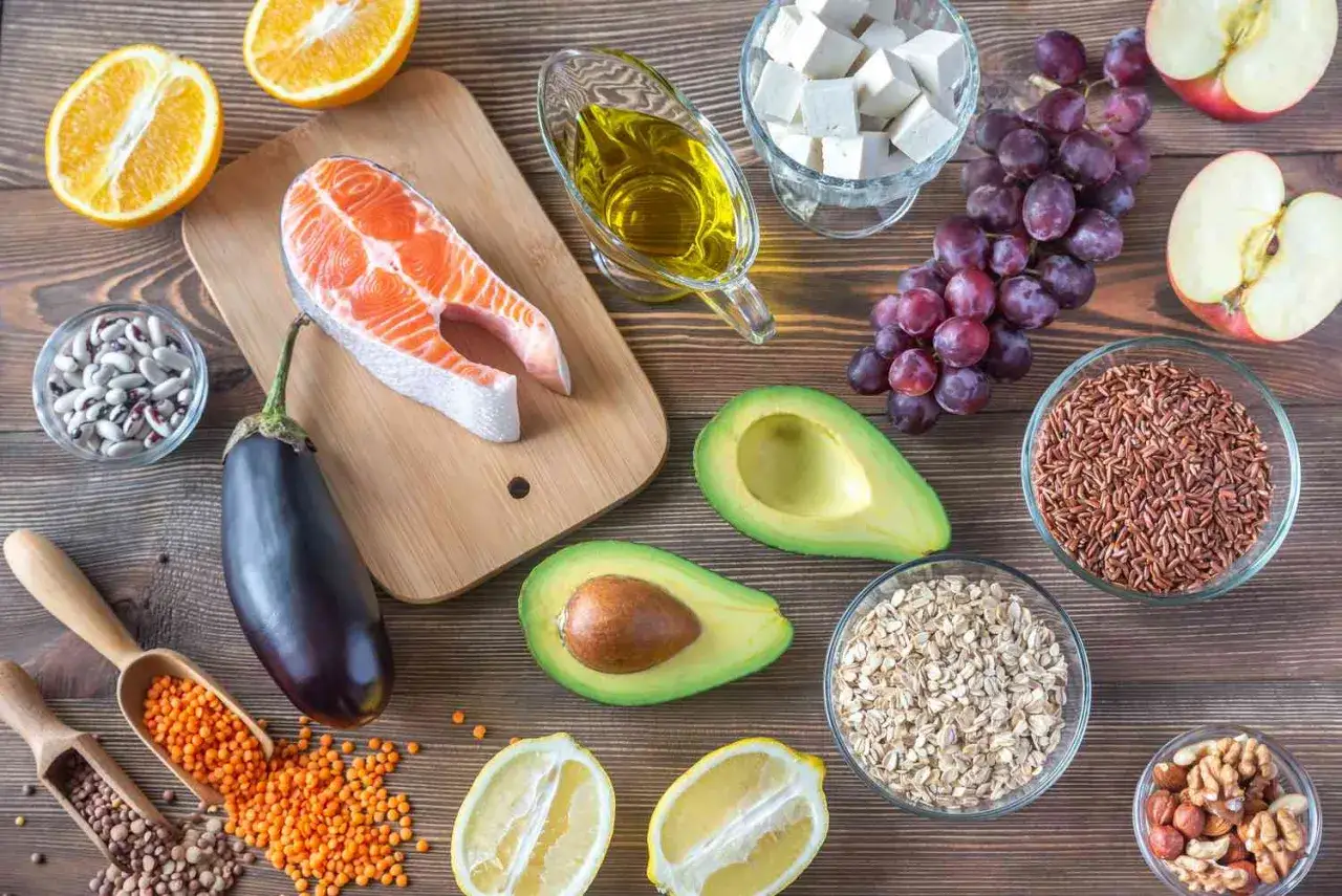 Składniki zdrowej diety na cholesterol: łosoś, awokado, orzechy, oliwa, owoce, warzywa, płatki owsiane, ryż.