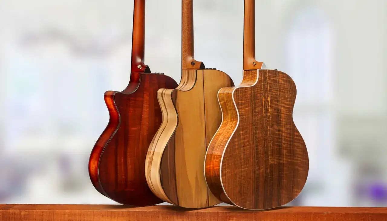 Trzy gitary akustyczne z pięknym, wzorzystym drewnem na korpusach. Każda z nich prezentuje inne, unikalne usłojenie drewna na gitarę.