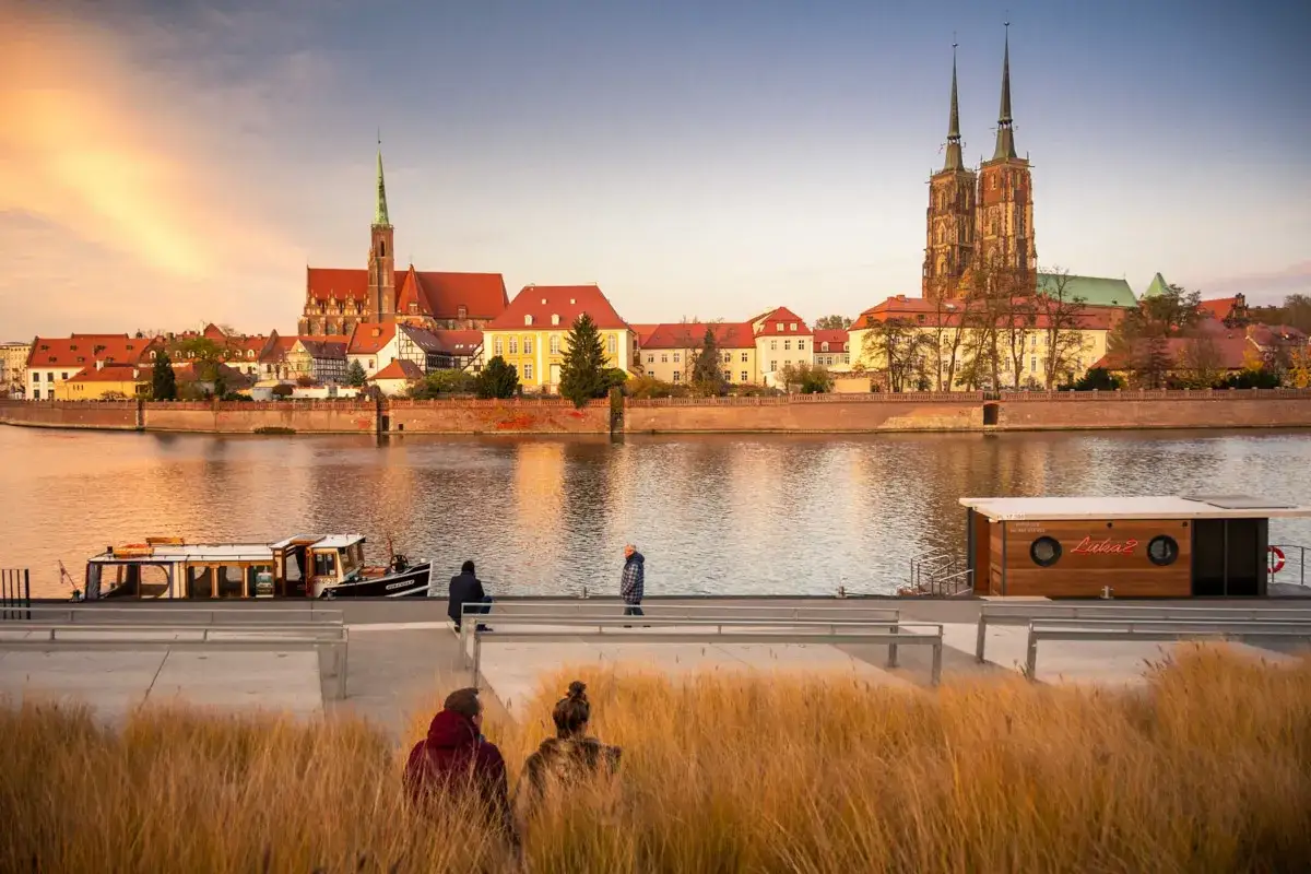 Zach&oacute;d słońca nad Odrą we Wrocławiu. Katedra i Ostrow Tumski to miejsca, kt&oacute;re warto zobaczyć.