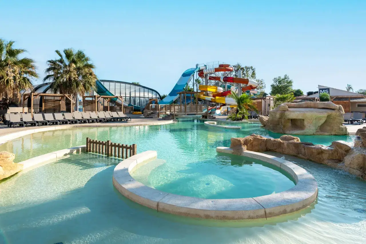 Un camping pour camping-car avec parc aquatique, des toboggans colorés et des piscines invitent à la détente sous le soleil.