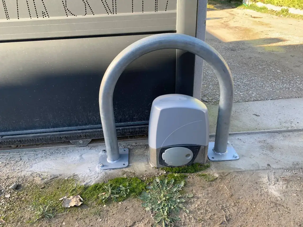 Une arche métallique protège le moteur d'un portail électrique.