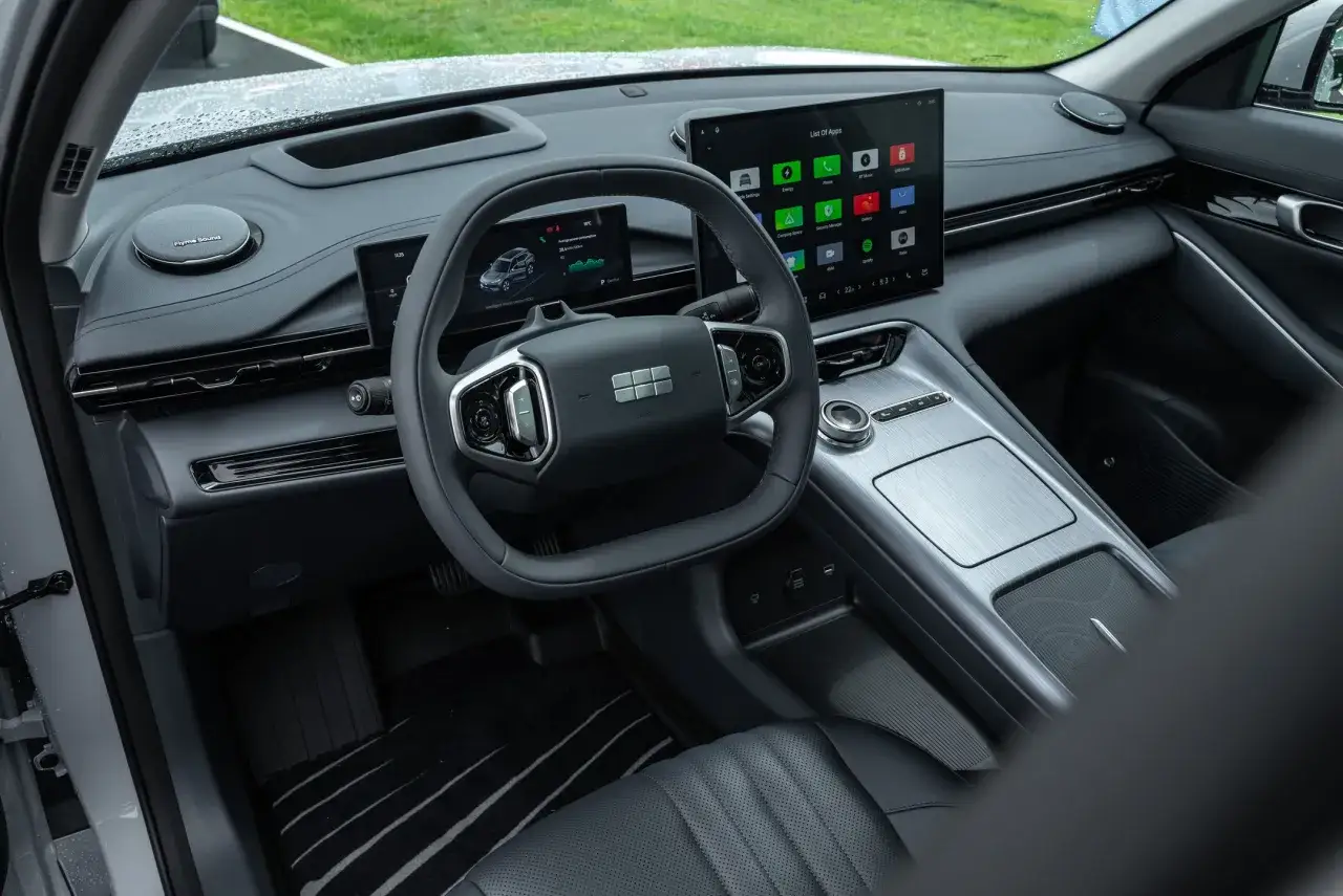 Wnętrze Geely EX5 z dużym ekranem dotykowym, cyfrowymi zegarami i nowoczesną konsolą środkową.