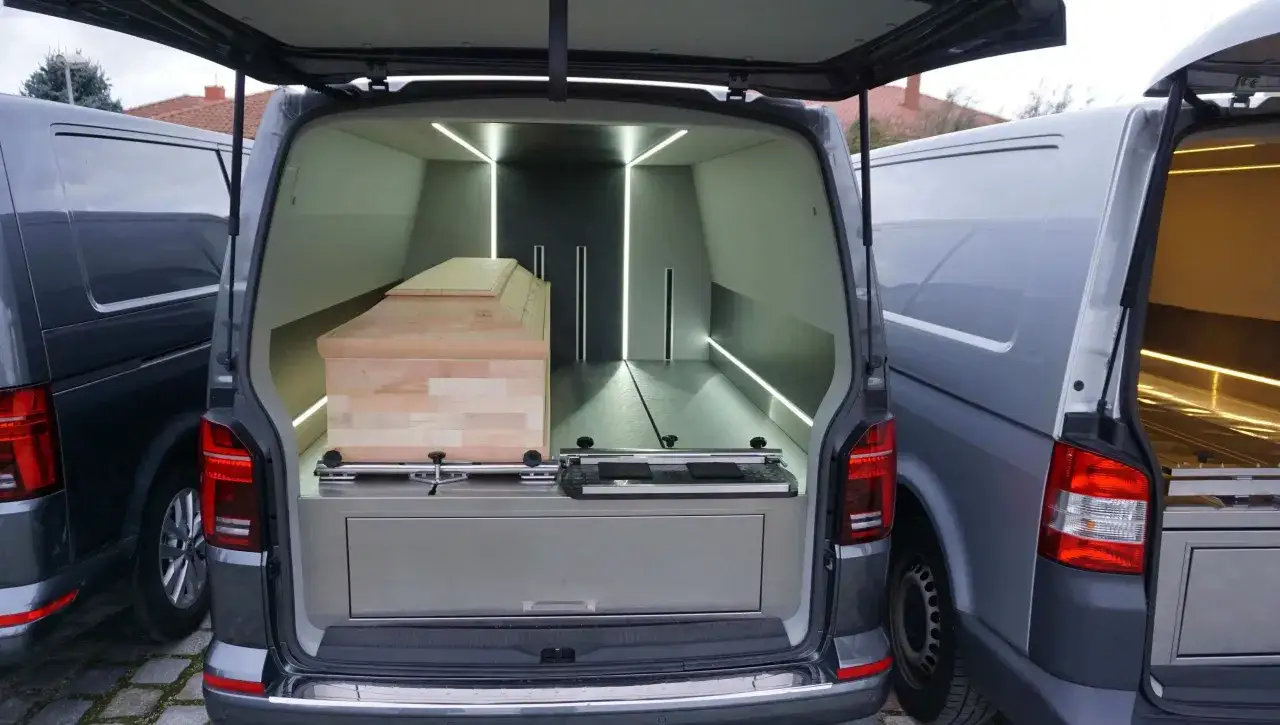 Wnętrze karawanu z trumną, gotowe do transportu zwłok powyżej 60 km. Nowoczesne oświetlenie LED podkreśla elegancję.