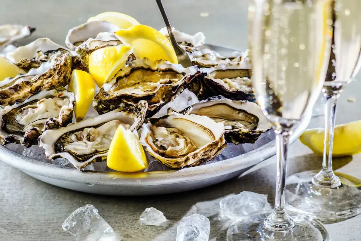 Ostras frescas con lim&oacute;n y copas de champ&aacute;n, un fest&iacute;n perfecto para celebrar el a&ntilde;o nuevo en Francia.