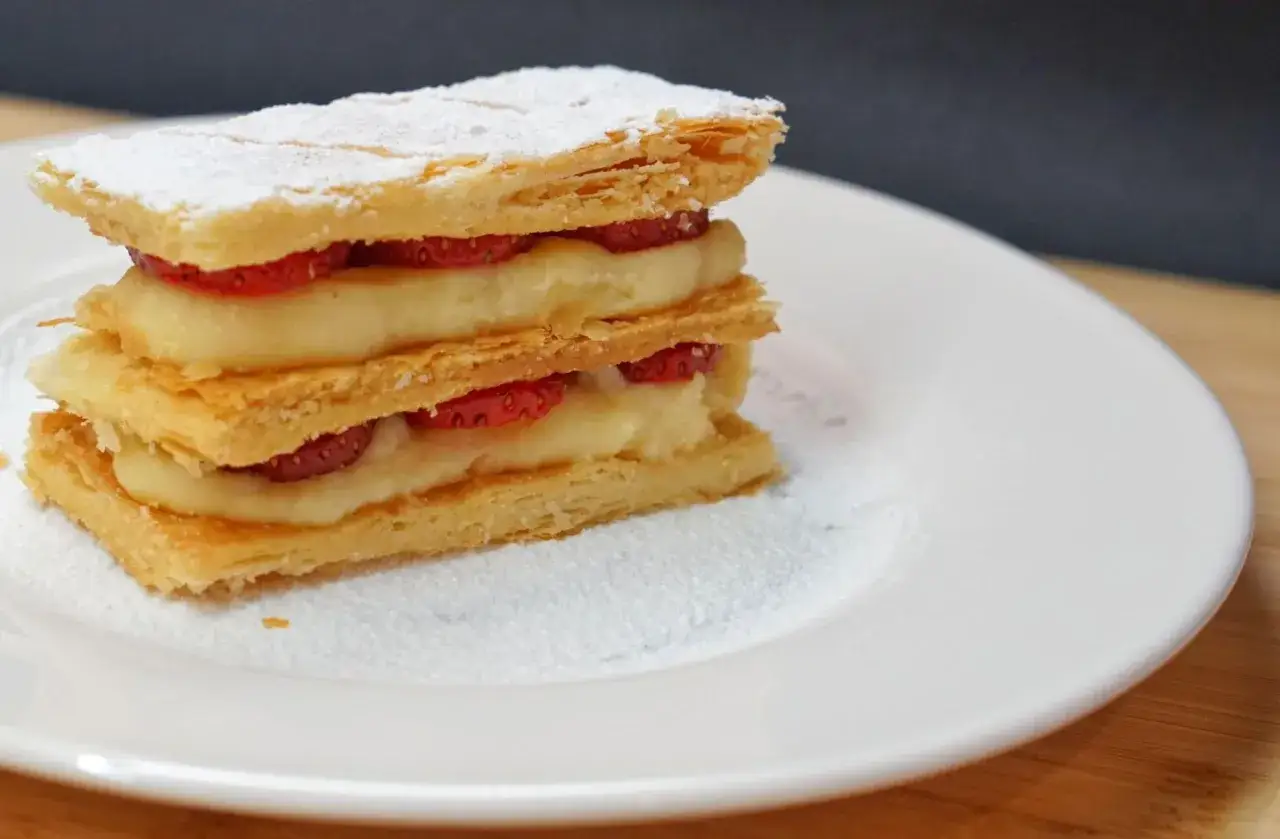 Milhojas con fresas y abundante crema pastelera, espolvoreado con az&uacute;car glas.