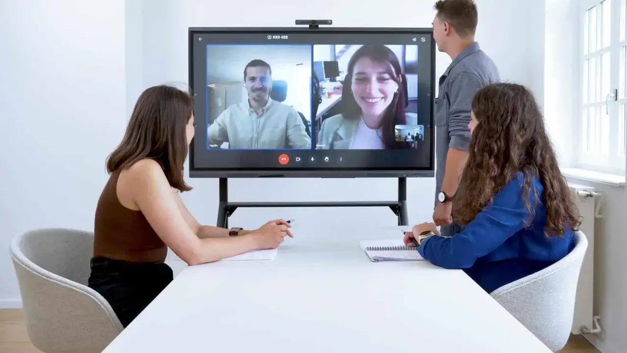 Ein gro&szlig;es Display zeigt ein Videokonferenzgespr&auml;ch. Hier wird gezeigt, was ist ein whiteboard: eine interaktive Tafel f&uuml;r Meetings.