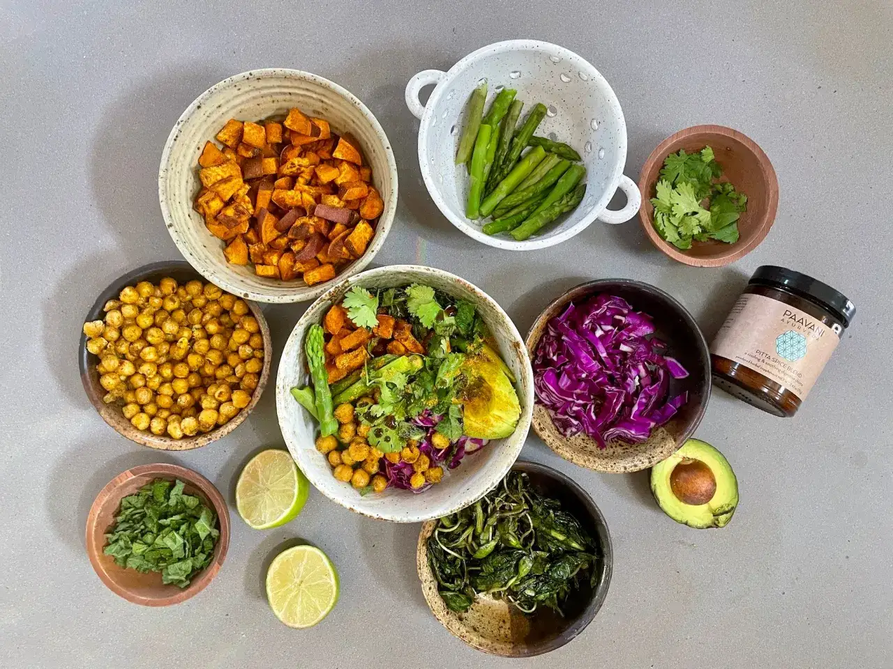 En härlig samling ingredienser för en balanserad pitta frukost: sötpotatis, kikärtor, sparris, rödkål, avokado och örter.