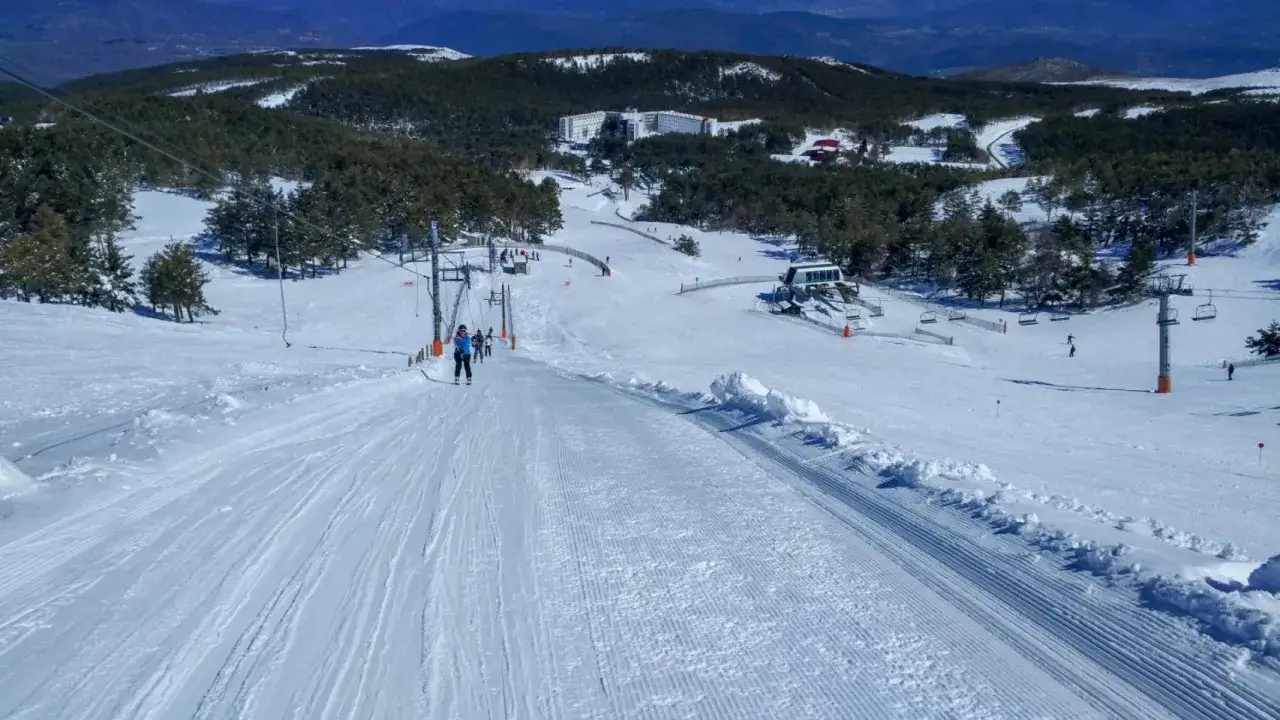 Esquí en la cabeza de Manzaneda, con pistas preparadas, telesillas y un hotel en la distancia.