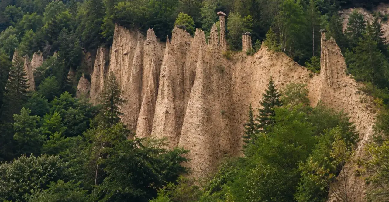 Le piramidi di terra del Val di Cembra, un paesaggio unico da vedere, emergono tra il verde dei boschi.