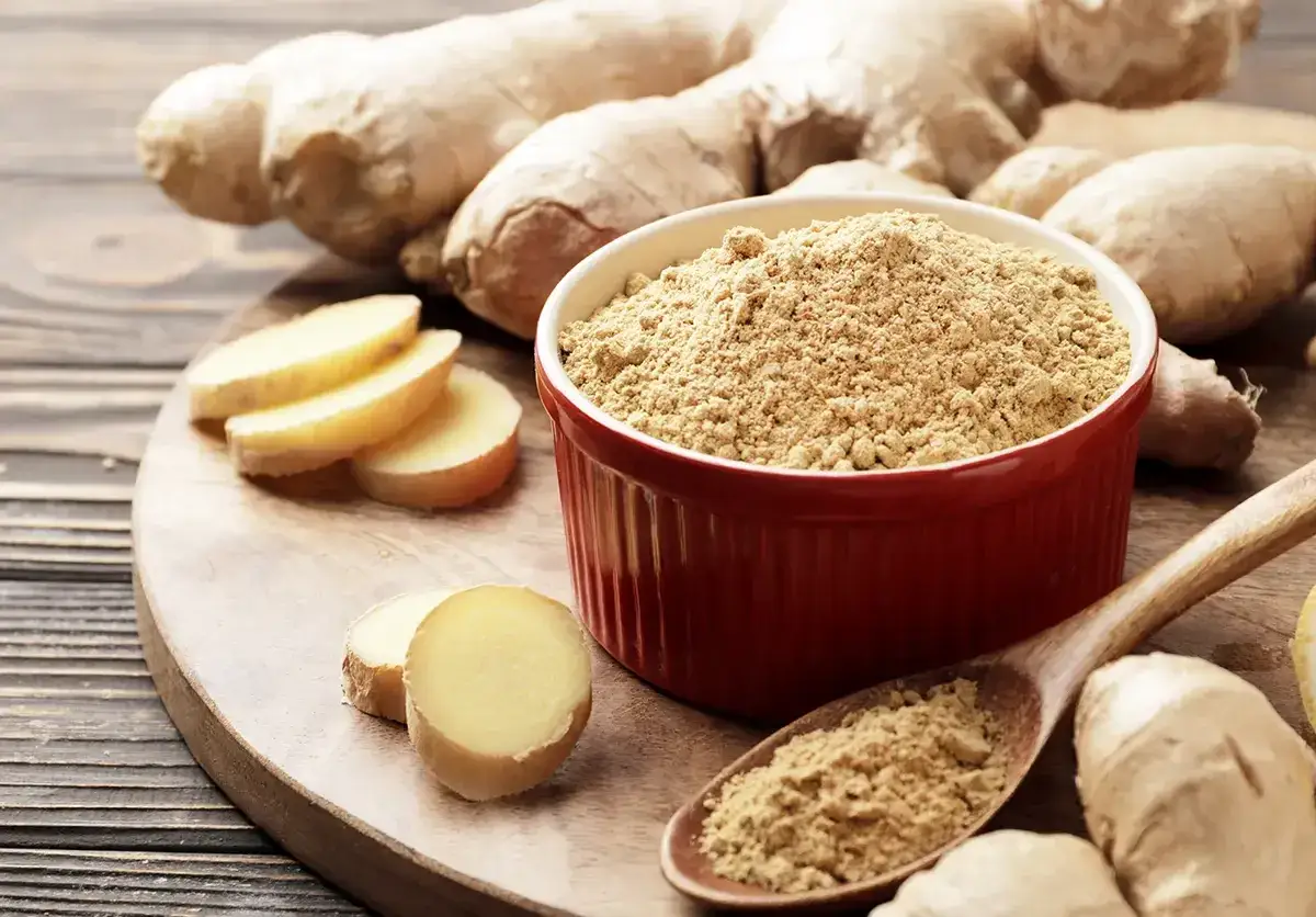 Imbir na co pomaga? Świeży imbir, plasterki i proszek w miseczce i na łyżce. Naturalne wsparcie dla zdrowia.