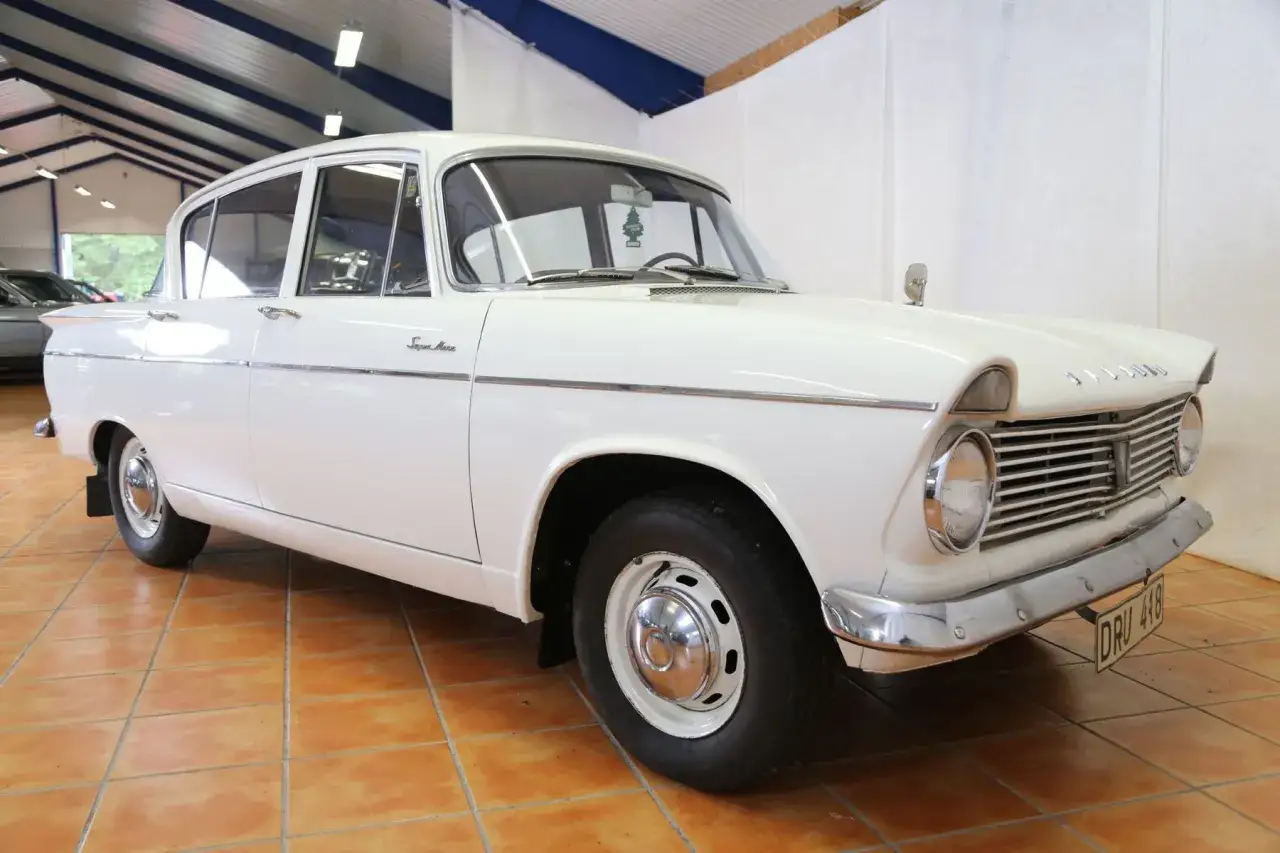 Vit Hillman Super Minx från 1960-talet, en klassisk bil med kromdetaljer och en tidstypisk interiör.