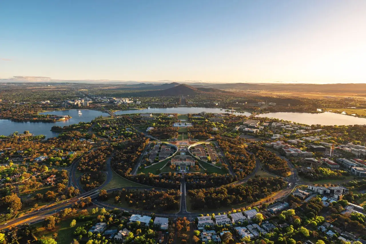 Widok z lotu ptaka na stolicę Australii, Canberrę, z jeziorem i budynkami rządowymi w centrum.