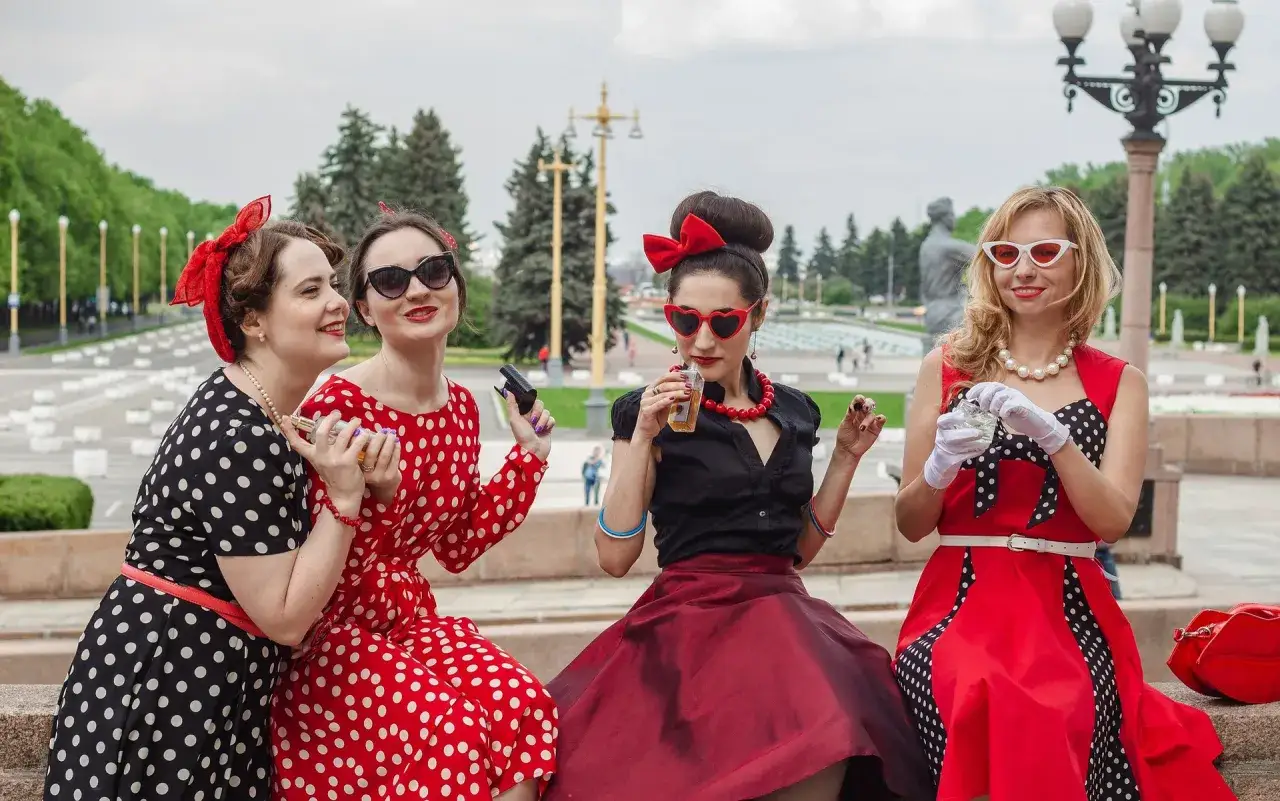 Quatre femmes au style pin-up ann&eacute;e 50, robes &agrave; pois, lunettes r&eacute;tro, et accessoires glamour.
